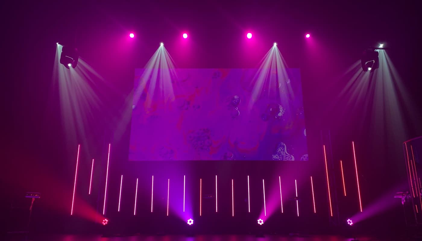 Empty stage under dramatic spotlights — placeholder imagery for Scott's speaking engagements